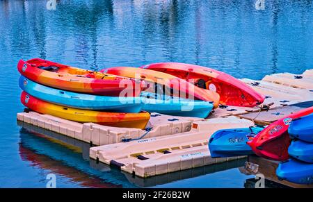 Colorful kayaks stacked on the dock ready for renting. Stock Photo
