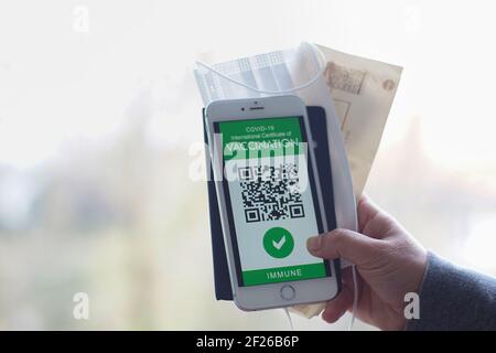 A woman Traveler shows health passport of vaccination certification on phone at airport, to certify that have been vaccinated of coronavirus covid-19 Stock Photo