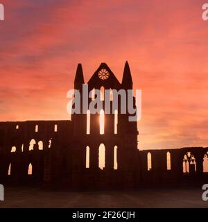 Historical 1995 sunset sky creating a silhouette archive view of part of the 1990s coastal landmark ruins at Whitby Benedictine Abbey a Grade I Listed building in the care of English Heritage a 90s archival history image in North Yorkshire England UK Stock Photo