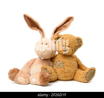 Brown teddy bear and cute rabbit sit on white isolated background Stock Photo