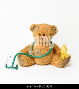 Brown teddy bear with a patch,  silk yellow ribbon in the shape of a loop Stock Photo