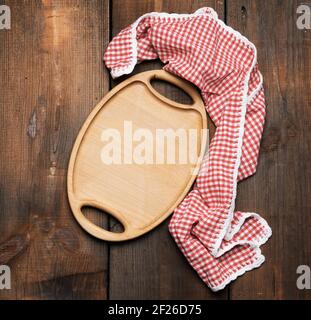 Empty oval brown wooden tray board on a wooden background Stock Photo