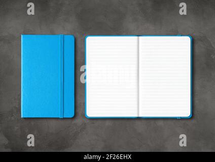 Blue closed and open lined notebooks on dark concrete background Stock Photo