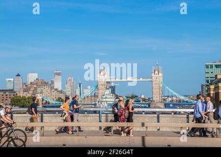2019 07 24 London UK Pedestrians crossing London Bridge with Tower Bridge raised for ship to pass under in the background - some movement blur in fore Stock Photo