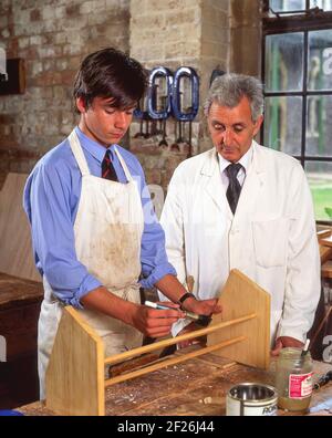 Teacher and male pupil in woodworking class, Surrey, England, United Kingdom Stock Photo
