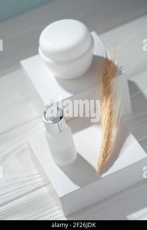 Top view of Pipet bottle and cream container on white boxes Stock Photo