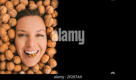 Happy woman face with perfect smile on a walnuts background with copy space Stock Photo