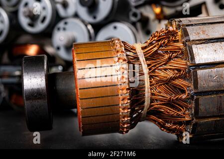 Small electric motors for driving domestic appliances. Electric devices stacked on a table. Dark background. Stock Photo
