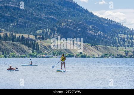 PENTICTON, CANADA - JULY 5, 2020: recreation time paddle boarding on scenic peaceful mountain lake. Stock Photo