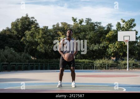 Serious black basketball player ready to perform throw Stock Photo