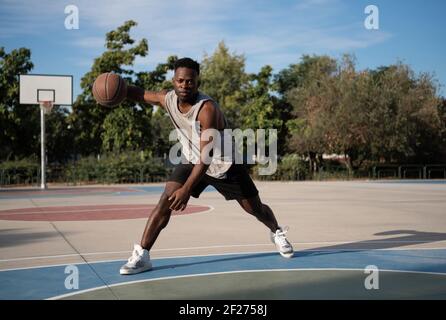 Black basketball player doing freestyle dribbling Stock Photo