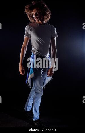 Skinny rock guy wearing  blue jeans pants isolated on black backgorund Stock Photo