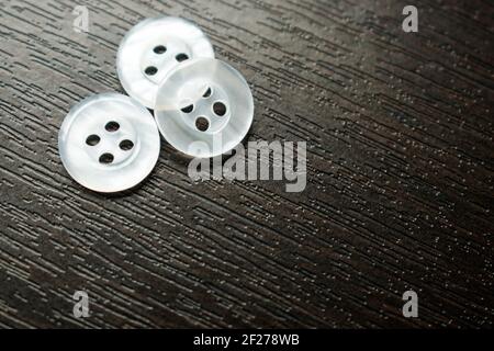 Some little white buttons on a black wooden table Stock Photo