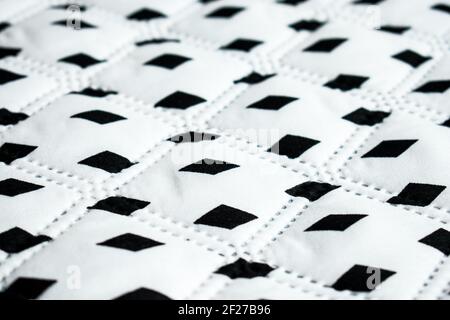 White, big and soft surface with some black rhombuses in a straight line Stock Photo