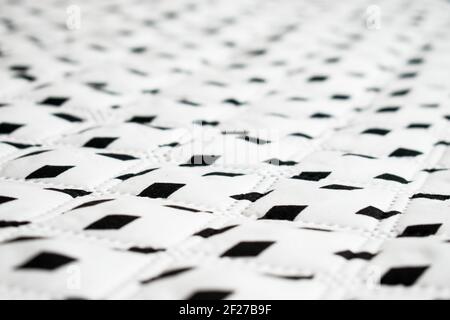 White, big and soft surface with some black rhombuses in a straight line Stock Photo