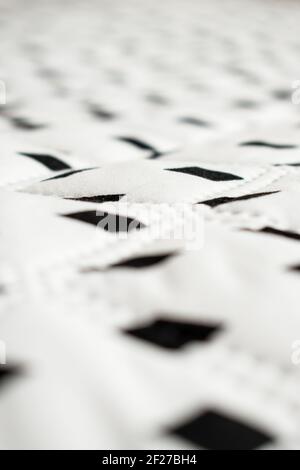 White, big and soft surface with some black rhombuses in a straight line Stock Photo