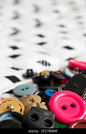 Some different colorful buttons on white, big and soft surface with some black diamonds in a straight line Stock Photo