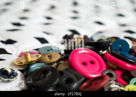 Some different colorful buttons on white, big and soft surface with some black diamonds in a straight line Stock Photo