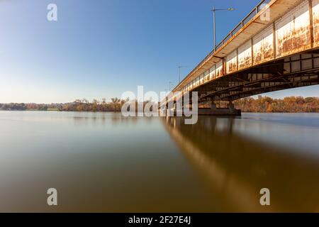 Long exposure landscape image featuring Theodore Roosevelt Island and bridge and Potomac river on a sunny afternoon in autumn. Trees on island have or Stock Photo