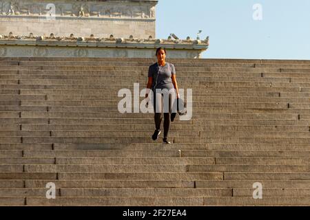 Washington DC, USA 11-06-2020: A  young hispanic girl is exercising on the steep stairs near Lincoln Memorial in DC. She wears tights, sports top and Stock Photo