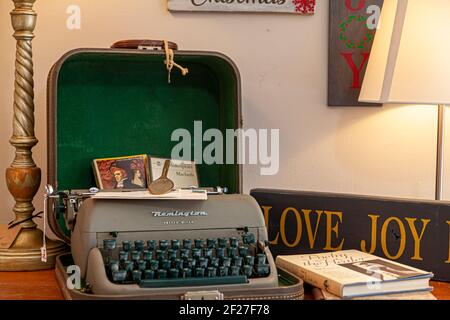 Clifton, VA , USA 11-14-2020: A stylish office decor with a green and gray antique Remington letter ritter model typewritter with its caseand a few ha Stock Photo