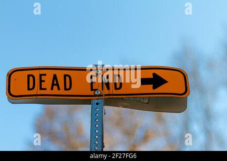 A close up isolated " Dead End " road sign with blurred background. It has versatile abstract and idiomatic uses for concepts that have no solution or Stock Photo