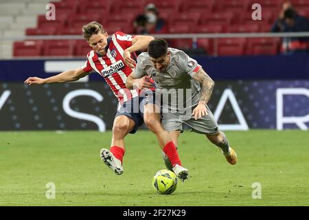 Madrid, Spain. 10th Mar, 2021. Atletico Madrid's Marcos Llorente (L) vies with Atletic Bilbao's Oscar de Marcos during a Spanish league football match between Atletico Madrid and Athletic Bilbao in Madrid, Spain, March 10, 2021. Credit: Edward F. Peters/Xinhua/Alamy Live News Stock Photo