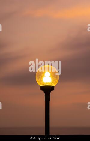 Garden lights lit up against a golden sky background. Stock Photo