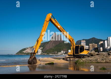 Rio de Janeiro, Brazil - April 6, 2017: Excavator builds a beach on the sea shore in Ipanema. Stock Photo