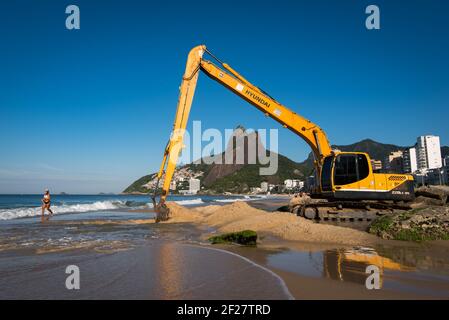 Rio de Janeiro, Brazil - April 6, 2017: Excavator builds a beach on the sea shore in Ipanema. Stock Photo
