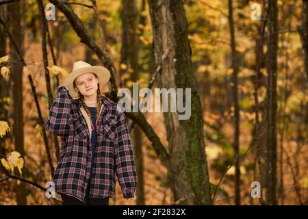 Woman walking through the woods during the autumn fall season. Stock Photo