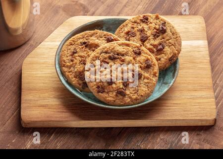 A closeup photo of chocolate chip cookies on a rustic wooden background Stock Photo