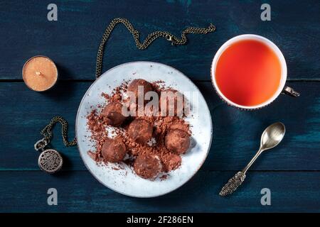 Chocolate truffles on a plate, with tea, overhead flat lay shot Stock Photo