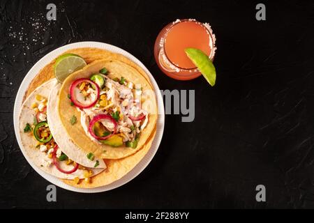 Tacos with chicken and avocado, with a Paloma cocktail Stock Photo