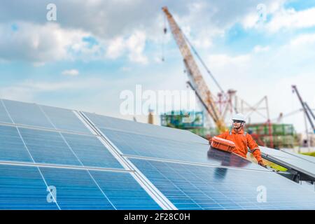 Engineers hold a tool for checking the performance of the solar panel to confirming systems working normally. Photovoltaic module idea for clean energ Stock Photo