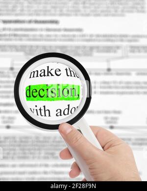 Magnifying glass in hand and word Decision Stock Photo