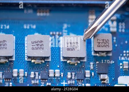 Technician is fixing a computer circuit board, hand and screwdriver. Stock Photo