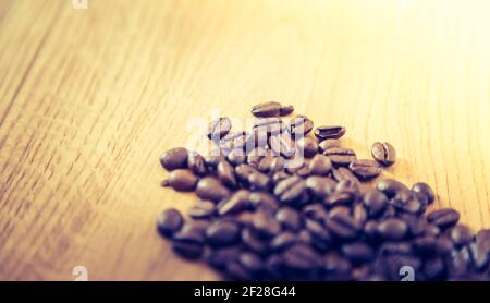 Close up of fresh roasted coffee beans on wooden background Stock Photo