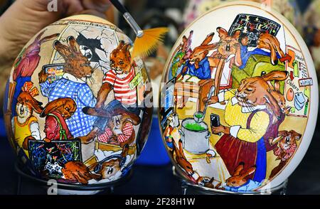 Leipzig, Germany. 08th Mar, 2021. Easter egg artist Kerstin Dischereit works a goose egg on two ostrich eggs in her "Easter Bunny Workshop," which she painted with the Corona theme "Home Chaos 2021." The illustrations depict bunnies from the nearly 100-year-old classic picture book "The Bunny School" struggling with home offices and homeschooling. Since the stock exchanges and Easter markets are cancelled again because of Corona, Dischereit uses the Internet for her extensive Easter egg collection. Credit: Waltraud Grubitzsch/dpa-Zentralbild/dpa/Ģ����ý Live News Stock Photo