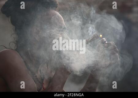 Kathmandu, NE, Nepal. 11th Mar, 2021. A Hindu sadhu smokes marijuana on the day of the Mahashivaratri festival at Pashupatinath temple premises in Kathmandu, Nepal, March 11, 2021. Credit: Aryan Dhimal/ZUMA Wire/Alamy Live News Stock Photo