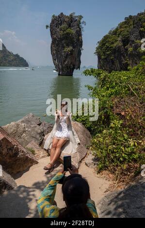 Tourist taking pictures at James Bond Island, featured in the movie “The Man with the Golden Gun”. Stock Photo