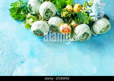 Happy Easter background. Spring flowers on a concrete blue background. Copy space. Stock Photo