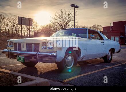 Rockville, MD, USA 03-10-2021: A vintage Oldsmobile Delta 88 model  sedan car parked in a parking lot at sunset. This is a seventh generation 1973 mod Stock Photo