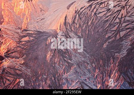 Winter snowy frosty patterns on the glass window. Winter magic. Frosty wonders. Abstract patterns. Stock Photo