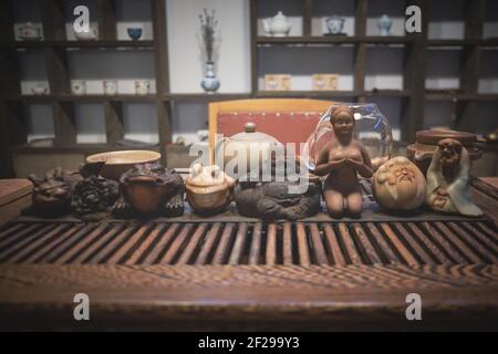 Tea god figurines and teaware on tea board Stock Photo