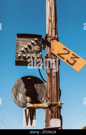 Railroad sign and lights, number 23, on wooden pole Stock Photo