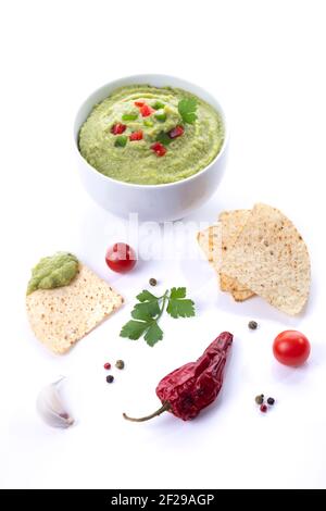 Bowl of guacamole and nachos isolated on white background. Vertical format. Stock Photo