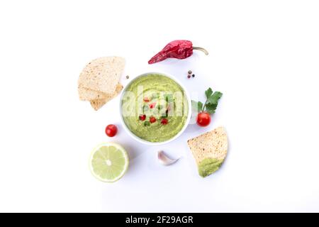 Bowl of guacamole and nachos isolated on white background.  Top view. Stock Photo