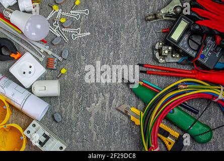 Electrical tools and a set of components for use in electrical installations on a gray background with a place for text Stock Photo