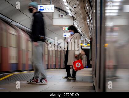 London- March 2021:  People in the London Underground wearing covid 19 face masks Stock Photo